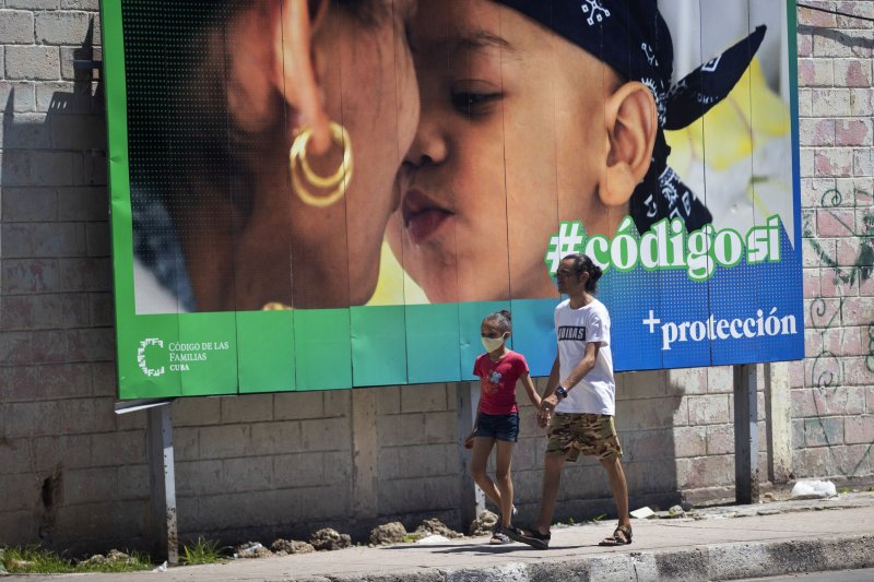 A man and a child walk past a banner that is part of the "Yes" campaign in the referendum on the family code in Havana, Cuba on Saturday. Photo by Yander Zamora/EPA-EFE